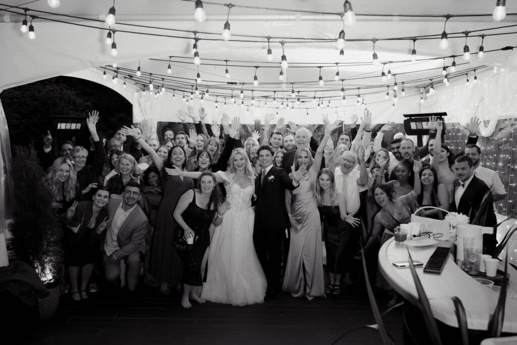 A black and white image of a bride and groom and their guests at Hemlock Hideaway during their Tofino wedding reception