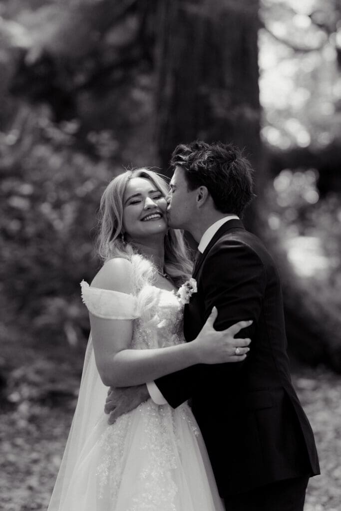 Romantic black and white images of a bride and groom in the Tofino rainforest on Vancouver Island cozying up in an embrace.