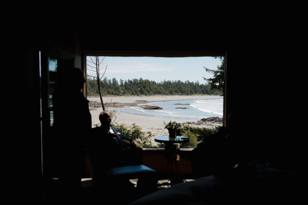 An image of the view of Chesterman Beach from the Wickaninnish Inn room of a groom getting ready for his wedding day.