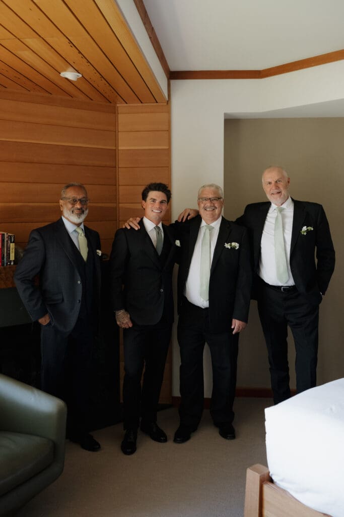 A groom with the father figures of his life - Dad, Step-Dad and soon to be Father-in-law - pose for a photo after getting dressed for his wedding in Tofino BC.