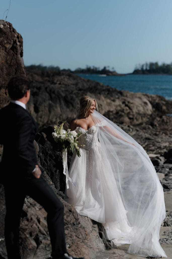 Bride wearing a cathedral-length veil during her beach portraits in Tofino after her wedding at the Wickaninnish Inn