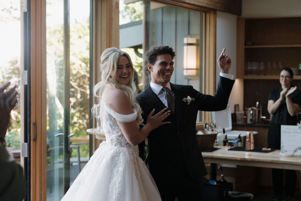 Bride and groom enter their reception in celebratory style with their guests at Hemlock Hideaway during their Tofino wedding reception