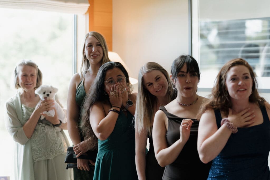 A bride's female family and friend's exclaim emotionally during their first look of her at Wickaninnish Inn.