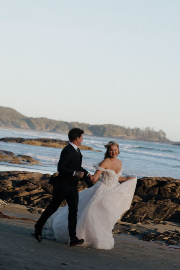 Newlyweds walking along the Pacific Ocean during sunset wedding photos in Tofino BC