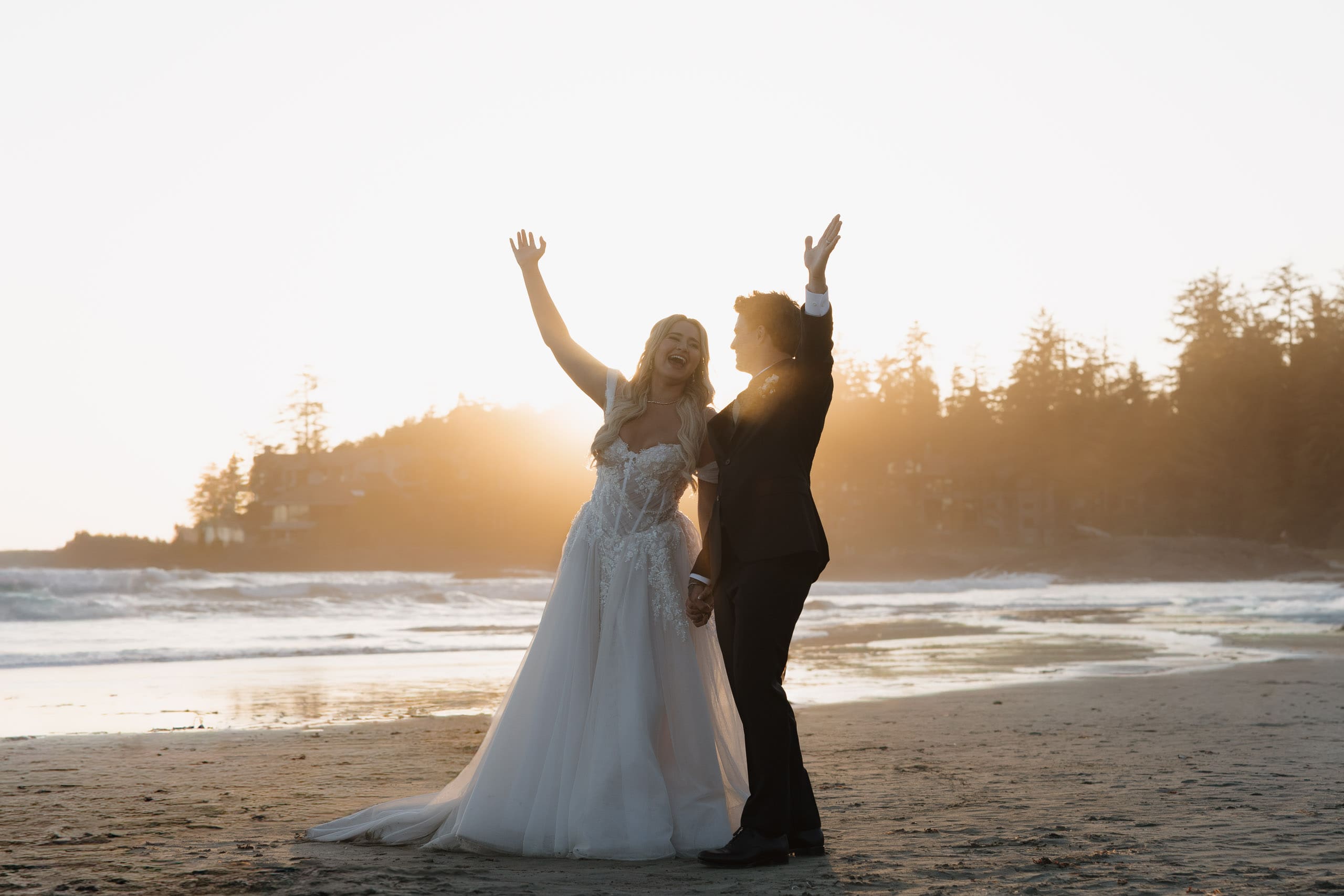Couple celebrates on Chesterman Beach following their wedding at the Wickaninnish Inn in Tofino BC