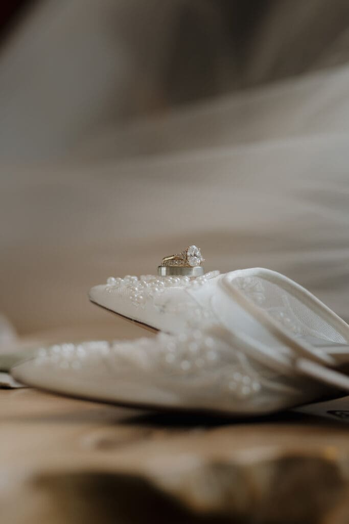 A bride's wedding sandals are featured with tiny details highlighted.