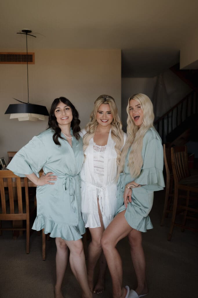 A bride and her bridesmaid pose for a getting ready photo prior to her Wickaninnish Inn on Chesterman Beach in Tofino BC. They are all wearing bridal robes.