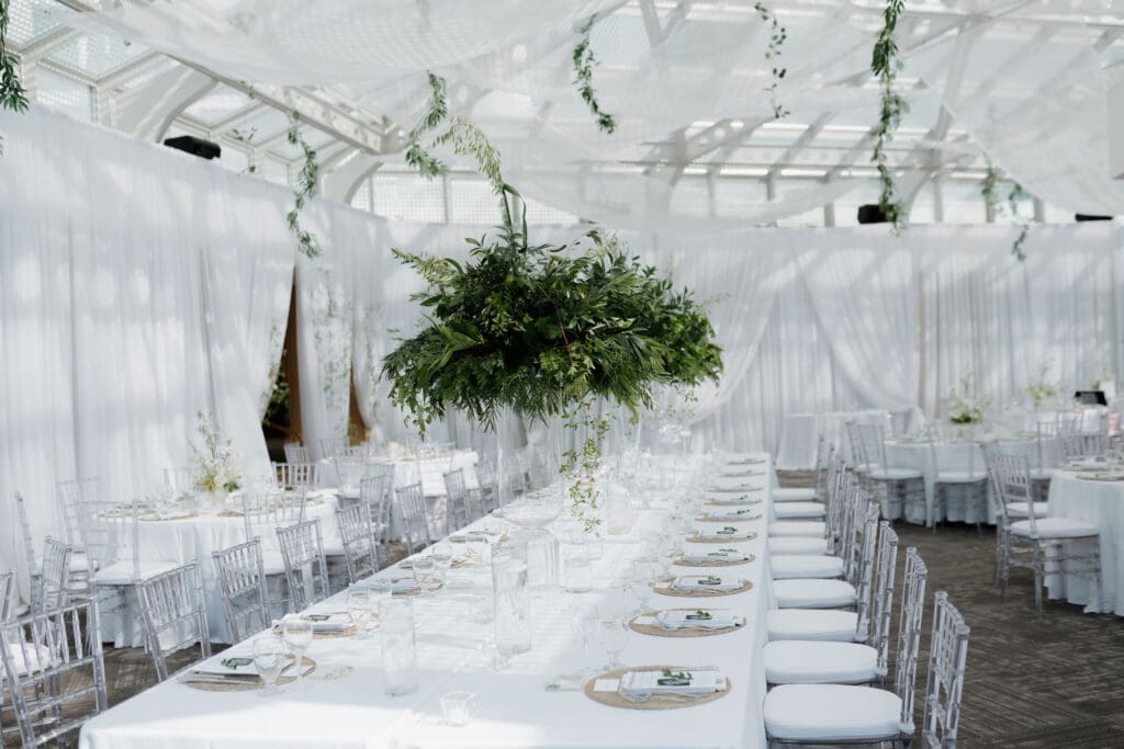 The dinner reception set up at Inn on Laurel Point in Victoria BC. White table scapes and drapery, plus greenery to accent the space.