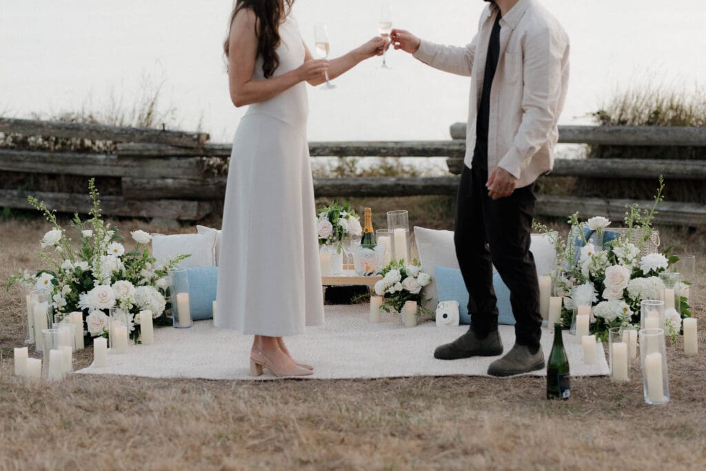 Styled picnic proposal setup with florals and candles, Victoria BC and share champagne to celebrate